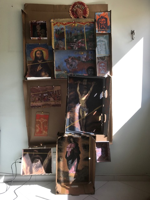 Fotografia da instalação "Oratório: Quem Pecou Demais? Eu, Não Fui.", Justino, acrílico em papelões, 2018.